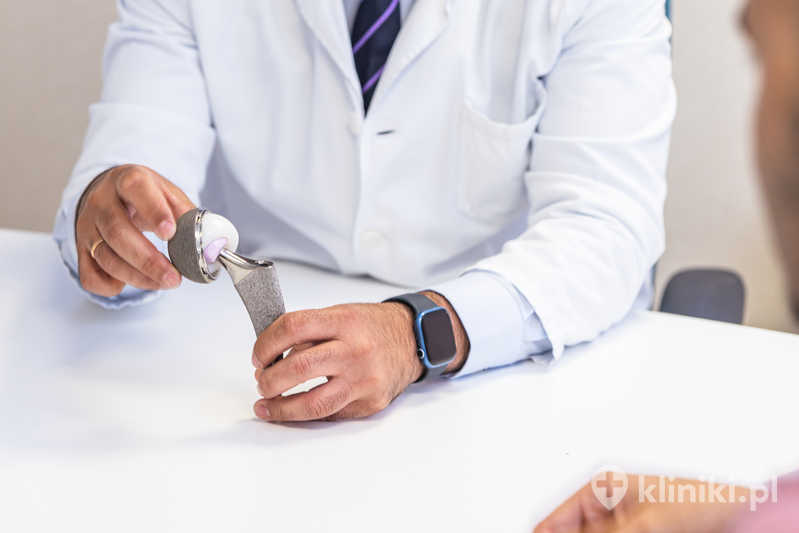 Chirurg ortopeda demonstrujący protezę stawu biodrowego Chirurg ortopeda demonstrujący protezę stawu biodrowego