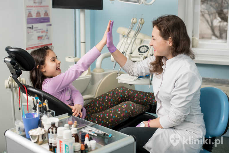 Szczęśliwa dentystka i pacjentka zadowolone z leczenia zębów w gabinecie stomatologicznym Szczęśliwa dentystka i pacjentka zadowolone z leczenia zębów w gabinecie stomatologicznym